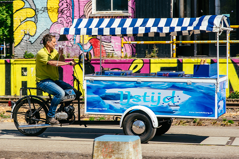 Compacte Zündapp brommer ijscowagen met witte en blauwe afwerking en een luifel.